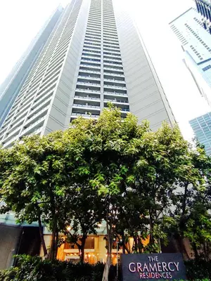 a tall building with a sign in front of a tree at High Sunset View with Fast WiFi, Pool, Big Balcony, Gym Access in Manila