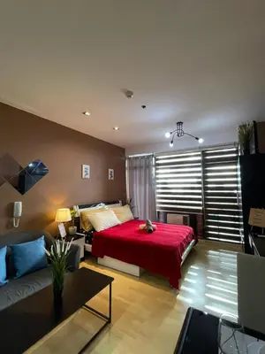 a bedroom with a red bed and a couch at High Sunset View with Fast WiFi, Pool, Big Balcony, Gym Access in Manila