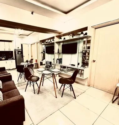 a living room with a couch and a table and chairs at Charming 2 Bedroom Makati Condo in Manila