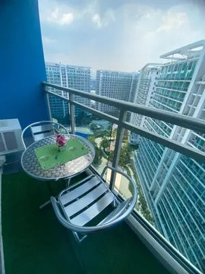a balcony with a table and chairs and some buildings at Condotel Azure Beachview in Manila