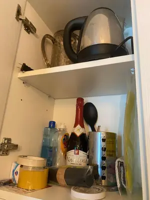 a kitchen shelf with a bottle of wine and other items at Condotel Azure Beachview in Manila