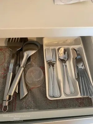 a drawer filled with silver utensils in a drawer at Condotel Azure Beachview in Manila