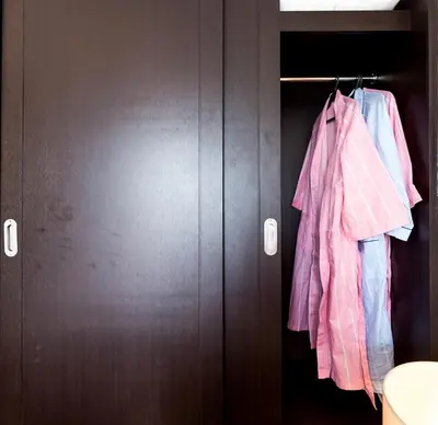 a closet with pink clothes hanging on a rod at Twin Bed Hotel Type by Ph Philstay in Manila