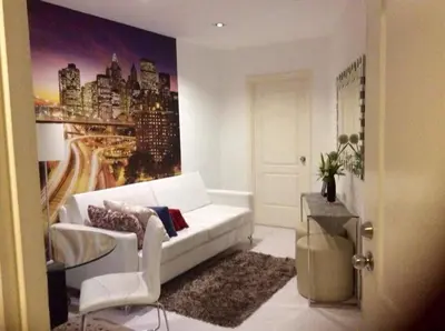 a living room with a white couch and a painting of a city at New York- Inspired Condo in Makati in Manila