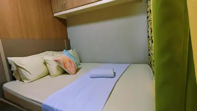a small bed with pillows on top of it at Family room big balcony pool view 2F in Manila