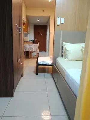 a small room with a bed and a table at Family room big balcony pool view 2F in Manila