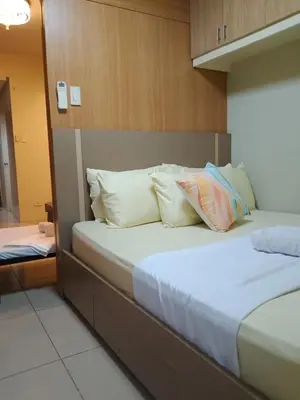 a bedroom with two beds with white pillows at Family room big balcony pool view 2F in Manila