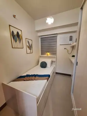 a small bedroom with a bed in a room at 2BR Apartment plus FREE parking Near NAIA in Manila