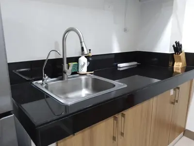 a kitchen with a sink and a black counter top at 2BR Apartment plus FREE parking Near NAIA in Manila