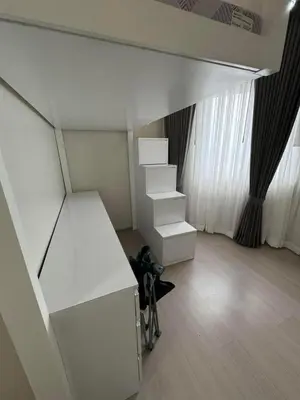 an empty room with white furniture and a staircase at Cozy Place near Eastwood in Manila