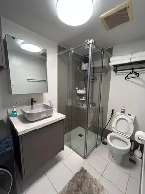 a bathroom with a shower and a toilet and a sink at Cozy Place near Eastwood in Manila