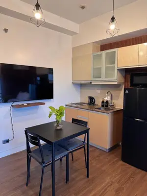 a kitchen with a table and a black refrigerator at Condo in Mckinley Hill Taguig in Manila
