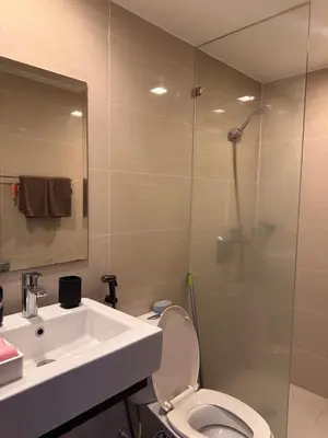 a bathroom with a toilet and a sink and a shower at Condo in Mckinley Hill Taguig in Manila