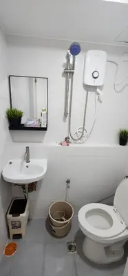 a white bathroom with a toilet and a sink at Cozy SpaciousLoft near MRT BONI in Manila