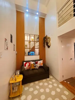 a living room with a couch and a table at Cozy SpaciousLoft near MRT BONI in Manila