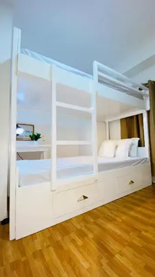 a white bunk bed in a room with a wooden floor at Cozy SpaciousLoft near MRT BONI in Manila
