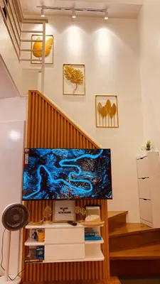 a living room with a large aquarium and stairs at Cozy SpaciousLoft near MRT BONI in Manila