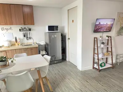 a kitchen with a white table and a refrigerator at 2 BR Unit with 180 degree view in Ortigas in Manila