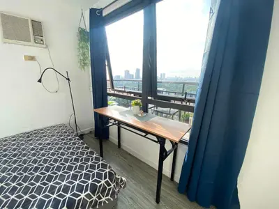 a room with a table and a large window at 2 BR Unit with 180 degree view in Ortigas in Manila