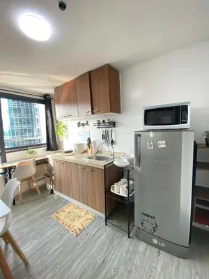 a small kitchen with a refrigerator and a sink at 2 BR Unit with 180 degree view in Ortigas in Manila