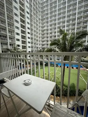 a white table and chairs on a balcony with buildings at Condo in Pasay in Manila