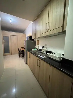 a kitchen with wooden cabinets and a table in it at Condo in Pasay in Manila