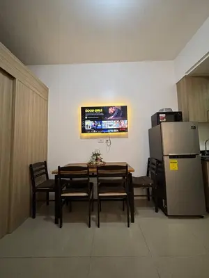 a dining room with a table and a refrigerator at Condo in Pasay in Manila