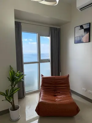 a living room with a couch and a large window at 175 Sqm Luxurious Modern 3 Bedrooms Facing Manila Bay Sunset, Airports, Okada, Solaire, MOA in Manila