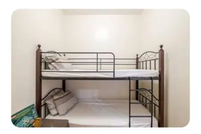 a bunk bed with two bunk beds in a room at Benjamin's crib staycation in Manila