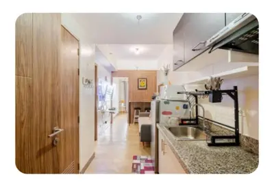 a kitchen with a sink and a refrigerator at Benjamin's crib staycation in Manila