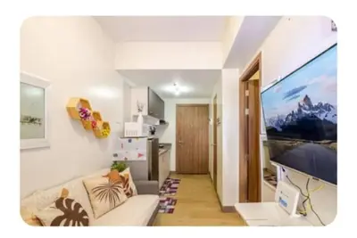 a living room with a couch and a flat screen tv at Benjamin's crib staycation in Manila