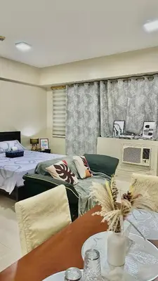 a living room with two beds and a table at Newport City across NAIA Terminal 3 by II JDs Aparthotel in Manila
