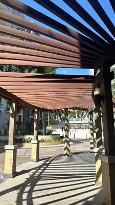 a large wooden pavilion with a building in the background at Newport City across NAIA Terminal 3 by II JDs Aparthotel in Manila