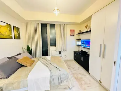 a bedroom with a bed and a flat screen tv at Miami 1909 in Manila