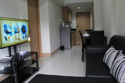 a living room with a couch and a kitchen at Cozy Urban Nest in Manila