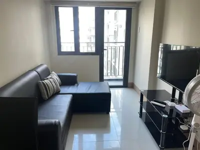 a living room with a couch and a flat screen tv at Cozy Urban Nest in Manila