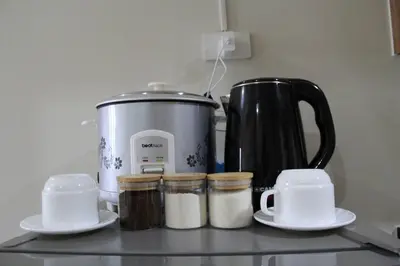 a kitchen counter with a coffee pot and spices at Cozy Urban Nest in Manila