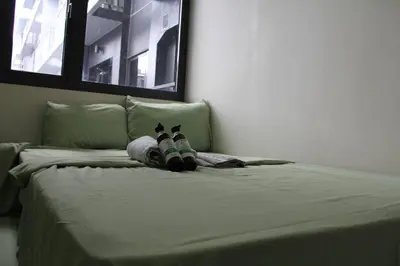 a bed with a stuffed animal laying on it at Cozy Urban Nest in Manila