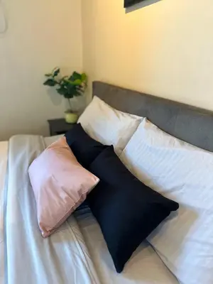 a bed with four pillows on top of it at Studio in Araneta City Fast Wifi Great Location in QC in Manila