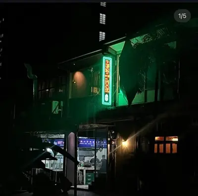 a green sign on the side of a building at night at Studio in Araneta City Fast Wifi Great Location in QC in Manila