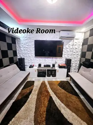 a living room with two couches and a flat screen tv at Natural Haven with Netflix Kubo Videoke & Alfresco Dining in Dasmariñas