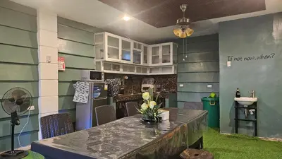 a kitchen with a table with flowers on it at Natural Haven with Netflix Kubo Videoke & Alfresco Dining in Dasmariñas