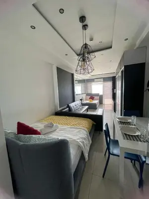 a bedroom with two beds and a table and a couch at 1553 Moa view bigcut in Manila