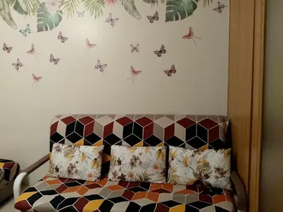 a bedroom with a bed with butterflies on the wall at 1103- 1bedroom 1 sofa bed 1 folding bed in Manila
