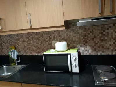 a microwave sitting on top of a kitchen counter at 1103- 1bedroom 1 sofa bed 1 folding bed in Manila