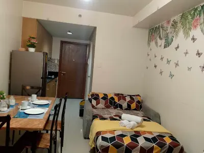a living room with a couch and a table at 1103- 1bedroom 1 sofa bed 1 folding bed in Manila