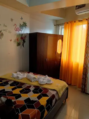 a bedroom with a bed and a cabinet with towels on it at 1103- 1bedroom 1 sofa bed 1 folding bed in Manila