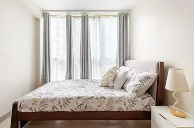 a white bedroom with a bed with a window at BGC Taguig Uptown 3BR corner unit with pool view, bath tub, wifi, parking, beside Landers BGC in Manila