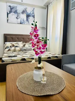 a table with a tree with pink flowers on it at Balauro's Haven in Trece Martires