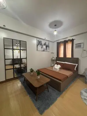 a living room with a large bed and a table at Balauro's Haven in Trece Martires